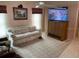 Cozy living room featuring a comfortable sofa, TV, and neutral carpet at 3604 Bula Ln, North Port, FL 34287