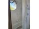Tiled shower and tub with a unique circular window providing natural light at 1612 Pocatello St, Sarasota, FL 34231