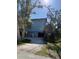 Two-story blue house surrounded by trees and foliage, with a garage underneath at 1612 Pocatello St, Sarasota, FL 34231