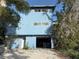 Two-story blue house with ample parking space and lush trees, offering a serene and inviting curb appeal at 1612 Pocatello St, Sarasota, FL 34231