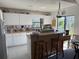 Well-lit kitchen featuring white cabinets, a peninsula island with seating, and an adjacent dining area with large windows at 1612 Pocatello St, Sarasota, FL 34231