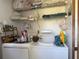 Practical laundry area with a washing machine, dryer, storage shelves, and essential supplies for easy laundry days at 1612 Pocatello St, Sarasota, FL 34231