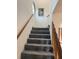 Carpeted stairway with wooden handrails leads to the upper floors, lit by a unique round window at 1612 Pocatello St, Sarasota, FL 34231
