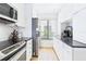 Well-lit kitchen featuring sleek stainless steel appliances, black countertops, and ample cabinet space at 6365 Bahia Del Mar Blvd # 210, St Petersburg, FL 33715