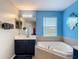 Bathroom featuring blue accent wall and a soaking tub at 18441 New London Ave, Land O Lakes, FL 34638