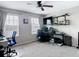 A well-lit bedroom featuring a ceiling fan, large windows, and a desk area set up for computers at 18441 New London Ave, Land O Lakes, FL 34638