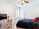 Well-lit bedroom features wood-look floors, neutral walls, and large window for natural light at 18441 New London Ave, Land O Lakes, FL 34638