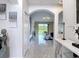 Bright hallway with stylish tile flooring, arched doorways, and view to the backyard at 18441 New London Ave, Land O Lakes, FL 34638