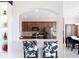 Open kitchen view features dark wood cabinets, stainless steel appliances, and cowhide chairs at 18441 New London Ave, Land O Lakes, FL 34638