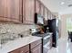 Well-equipped kitchen with stainless steel appliances, wood cabinetry, mosaic backsplash, and white marble countertops at 18441 New London Ave, Land O Lakes, FL 34638