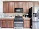 Modern kitchen with wood cabinets, stainless steel appliances, and a decorative tile backsplash at 18441 New London Ave, Land O Lakes, FL 34638