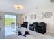 Bright living room with tile floors, comfortable seating, and sliding glass doors to outdoor patio at 18441 New London Ave, Land O Lakes, FL 34638