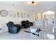Bright living room with tile floors, modern art, and comfortable black leather seating at 18441 New London Ave, Land O Lakes, FL 34638