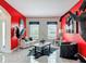 Bright living room with striking red accent wall, modern furniture, and lots of natural light at 18441 New London Ave, Land O Lakes, FL 34638