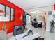 Eclectic living room featuring bold red walls, unique art pieces, and modern tile flooring at 18441 New London Ave, Land O Lakes, FL 34638