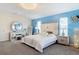 Bright primary bedroom with blue accent wall, carpeted floors, crystal lamps, and a makeup vanity at 18441 New London Ave, Land O Lakes, FL 34638