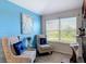 Bright sitting area featuring decorative artwork, chair, and large windows at 18441 New London Ave, Land O Lakes, FL 34638