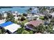 Aerial view of a home with palm trees, water views, and other houses nearby at 13116 Boca Ciega Ave, Madeira Beach, FL 33708