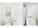 All-white bathroom features a window, toilet, towel rack, sink, and cabinet at 13116 Boca Ciega Ave, Madeira Beach, FL 33708
