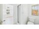 All-white bathroom with window, toilet, and shower behind a white curtain at 13116 Boca Ciega Ave, Madeira Beach, FL 33708