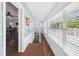 Hallway with hardwood floors, big windows with views, staircase and doorway to the living area at 13116 Boca Ciega Ave, Madeira Beach, FL 33708
