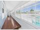 Bright hallway with hardwood floors, and big windows with views and white trim at 13116 Boca Ciega Ave, Madeira Beach, FL 33708