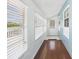Hallway with hardwood floors, and big windows with views, leading to a white front door at 13116 Boca Ciega Ave, Madeira Beach, FL 33708