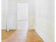 Hallway with wood-look tile flooring, leading to other rooms, offering potential for customization and updates at 13116 Boca Ciega Ave, Madeira Beach, FL 33708