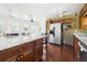 Kitchen with granite countertops, stainless appliances, wood cabinets, mosaic tile backsplash and wood floors at 13116 Boca Ciega Ave, Madeira Beach, FL 33708