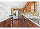Kitchen with wood cabinets, granite counters, mosaic tile backsplash and stainless refrigerator at 13116 Boca Ciega Ave, Madeira Beach, FL 33708