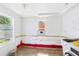 Laundry room with tile flooring and bright windows, offering potential for customization and updates at 13116 Boca Ciega Ave, Madeira Beach, FL 33708