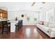Living room featuring wood floors, ceiling fan, a sofa, Kitchen with eat-in bar at 13116 Boca Ciega Ave, Madeira Beach, FL 33708