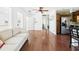 Living room featuring wood floors, ceiling fan, a sofa, leading to various rooms at 13116 Boca Ciega Ave, Madeira Beach, FL 33708