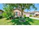 Attractive single-story home featuring a well-maintained lawn and mature tree providing shade and curb appeal at 15279 Stone House Dr, Brooksville, FL 34604