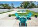 Paved and white gravel backyard featuring turquoise adirondack chairs, flowers and privacy fencing at 418 40Th S Ave, St Petersburg, FL 33705