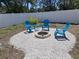 Relaxing backyard with Adirondack chairs, fire pit, and white gravel surrounded by a white vinyl fence at 418 40Th S Ave, St Petersburg, FL 33705