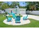 Backyard includes garage, fire pit, & several turquoise adirondack chairs, creating a great outdoor space at 418 40Th S Ave, St Petersburg, FL 33705