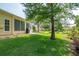 Yellow house featuring a well-kept lawn, brick patio, and green outdoor space at 1188 Royal Blvd, Palm Harbor, FL 34684