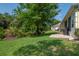 Yellow house showcasing a beautiful green lawn, brick patio, and a grill at 1188 Royal Blvd, Palm Harbor, FL 34684