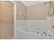 Well-lit bathroom showcasing a jetted tub, separate shower, and tile surround at 1188 Royal Blvd, Palm Harbor, FL 34684