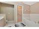 Bright bathroom featuring a glass door shower, a soaking tub, and neutral color tile flooring at 1188 Royal Blvd, Palm Harbor, FL 34684