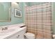 Bright bathroom with a vanity and a shower featuring a pastel striped shower curtain at 1188 Royal Blvd, Palm Harbor, FL 34684