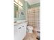 Bathroom features stylish vanity and a shower with a decorative pastel striped shower curtain at 1188 Royal Blvd, Palm Harbor, FL 34684