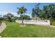Community pool area with a gazebo, a fence, palm trees, lounge chairs and a view of the community at 1188 Royal Blvd, Palm Harbor, FL 34684