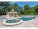 Inviting community pool area featuring a spa, gazebo, and plenty of lounge chairs amidst lush greenery at 1188 Royal Blvd, Palm Harbor, FL 34684
