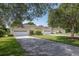 Neighborhood of well-maintained homes with driveways and green lawns under the shade of mature trees at 1188 Royal Blvd, Palm Harbor, FL 34684