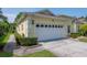 Spacious two-car garage with decorative windows, complemented by well-maintained landscaping and a clean driveway at 1188 Royal Blvd, Palm Harbor, FL 34684