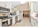 Open kitchen with granite countertops, stainless appliances, white cabinets, and seamless flow to other rooms at 1188 Royal Blvd, Palm Harbor, FL 34684
