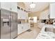 Well-lit kitchen featuring white cabinets, modern appliances, granite counters, and tile flooring at 1188 Royal Blvd, Palm Harbor, FL 34684