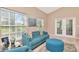 Bright living room features tile floors, large windows, and comfortable blue furniture at 1188 Royal Blvd, Palm Harbor, FL 34684